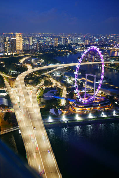 Singapore, Singapore - August 22 2007:  Parliament Of Singapore by night with the Singapore river in the foreground, the North Bridge on the left and also, the Old Supreme Court Building, the Supreme Court Of Singapore, the Peninsula Excelsior and the Fairmont Singapore around and behind.