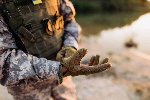 um soldado do sexo masculino coloca luvas táticas - marines camouflage camouflage clothing male - fotografias e filmes do acervo