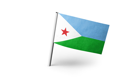 Small paper flag of Djibouti pinned. Isolated on white background. Horizontal orientation. Close up photography. Copy space.