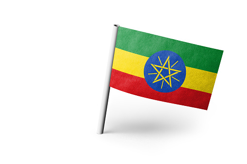 Small paper flag of Ethiopia pinned. Isolated on white background. Horizontal orientation. Close up photography. Copy space.