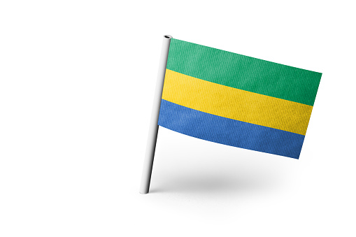 Small paper flag of Gabon pinned. Isolated on white background. Horizontal orientation. Close up photography. Copy space.