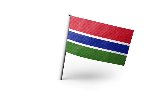 Small paper flag of Gambia pinned. Isolated on white background. Horizontal orientation. Close up photography. Copy space.