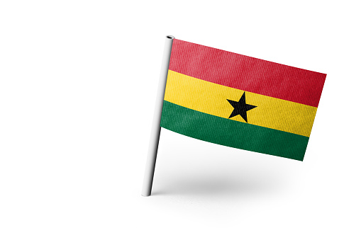 Small paper flag of Ghana pinned. Isolated on white background. Horizontal orientation. Close up photography. Copy space.