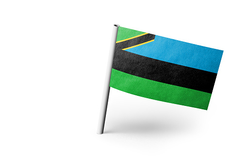 Small paper flag of Zanzibar pinned. Isolated on white background. Horizontal orientation. Close up photography. Copy space.