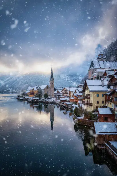 The beautiful village of Hallstatt in the Austrian Alps, during a winter day with falling snow and clouds
