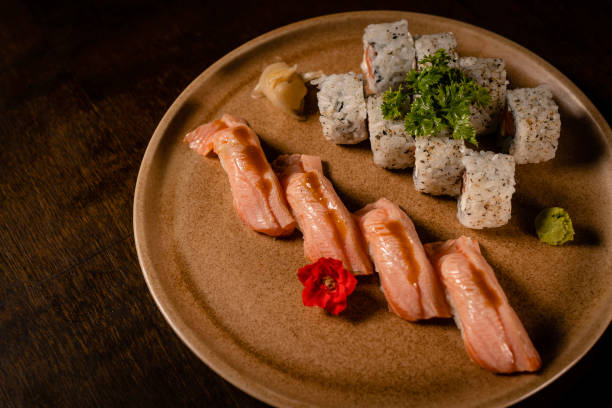 uramaki de salmón + niguiri de panceta de salmón - niguiri sushi fotografías e imágenes de stock