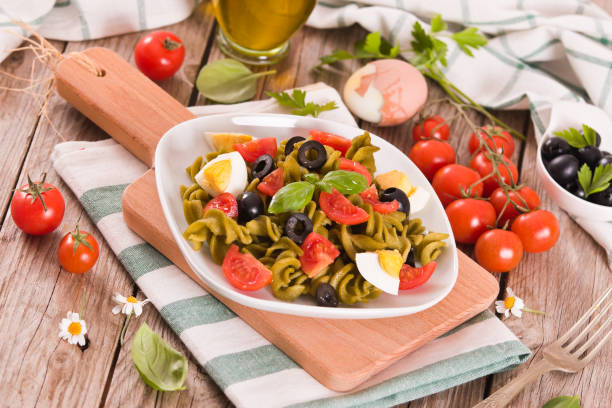 istock Fusilli pasta with cherry tomatoes, eggs and black olives. 1442482637