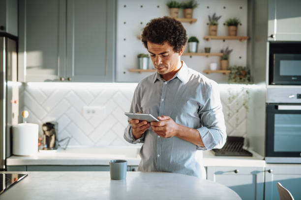 istock Multiracial mid adult man working from domestic kitchen and checking mail before leaving to work 1442483665