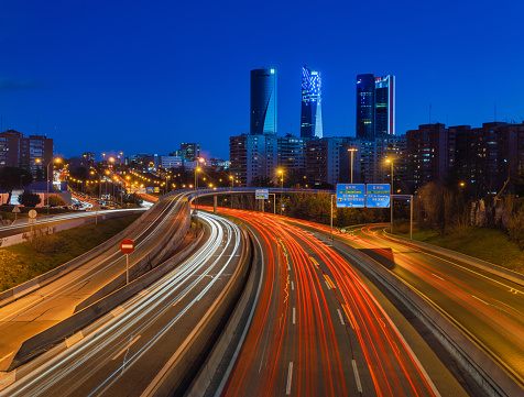 Madrid, Spain - January 27- 2019: Long exposure shot taken from Ramon y Cajal footbridge looking towards the 4 Towers. Hundreds of cars coming and going from the city.