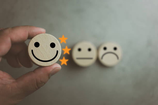 istock Customer satisfaction survey concept. Customer selects wooden cube with happy face icon and three star. 1442489005