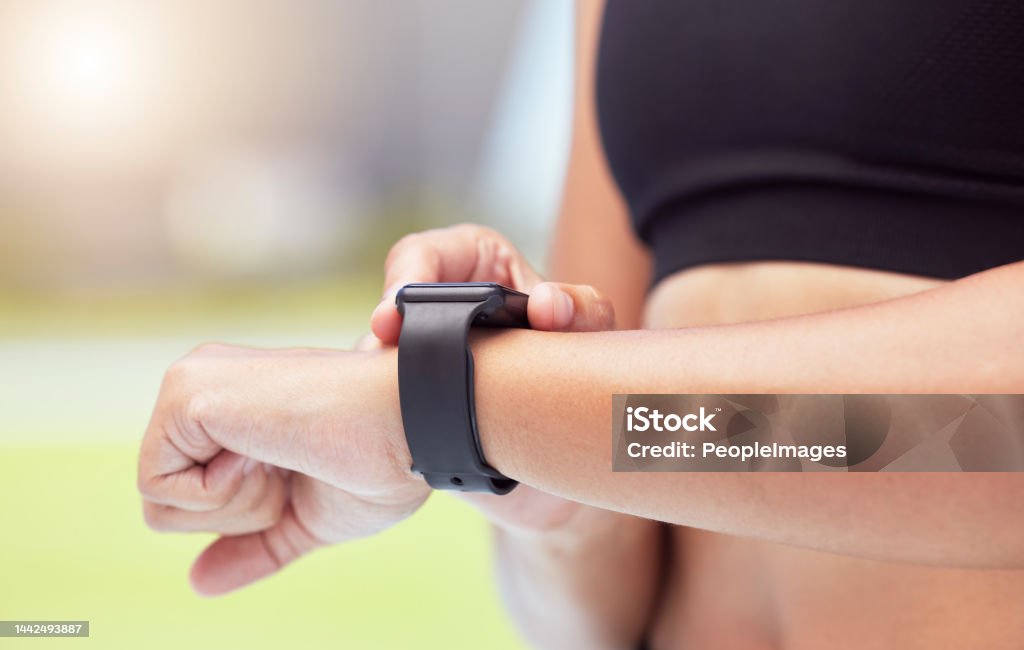 Smartwatch on hands of runner to track woman running time, health stats and train for competition race. Smart watches help competitive performance, motivate and inspire athlete to improve record time Woman runner uses smartwatch to track running time, working out for fitness and training for competiion race . A healthy runner means good diet, stretching exercise and a competitive mental attitude 20-24 Years Stock Photo