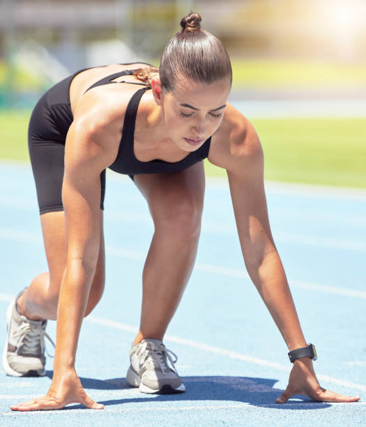 Runner, woman and focus of a athlete about to start a run on a sport track outdoor. Fitness, sports and motivation for workout training for running in a exercise for healthy living and strong cardio corredora, mujer y foco de un atleta a punto de comenzar una carrera en una pista deportiva al aire libre. fitness, deportes y motivación para el entrenamiento de entrenamiento para correr en un ejercicio para una vida saludable y cardio fuerte