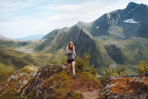 Woman trail running in mountains training outdoor travel healthy lifestyle adventure hiking vacations motivation endurance concept Norway nature Senja island