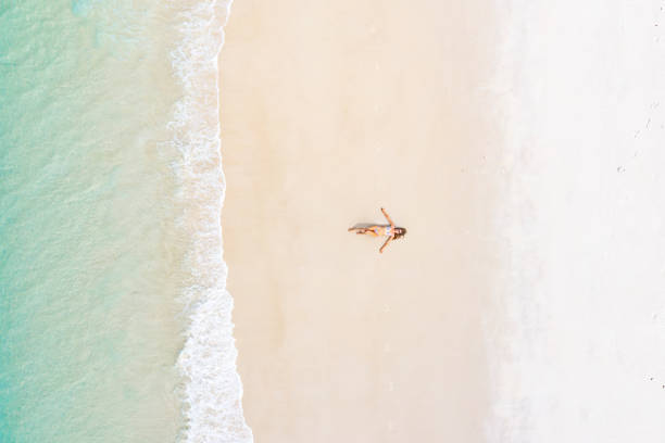 istock Beautiful woman sunbathing on pristine beach 1442497531