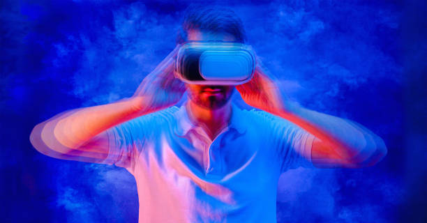 istock blured man with goggle headset of virtual reality on neon blue background 1442498738