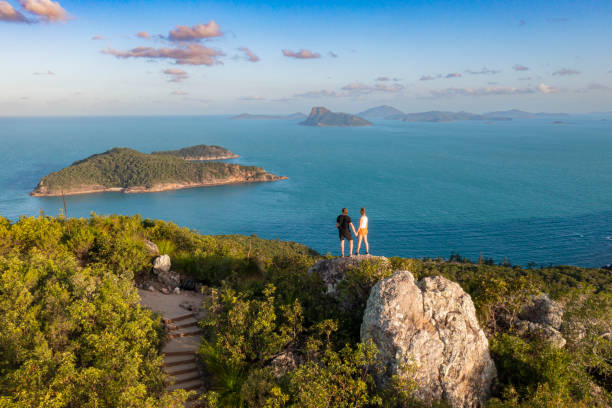 istock Couple Standing atop mountain overlooking deep blue ocean 1442498864