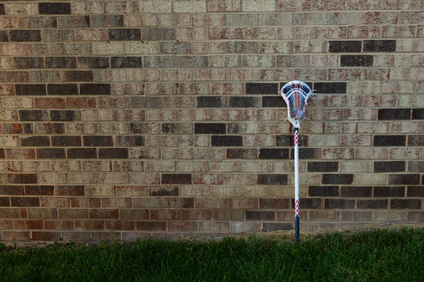 Men's Lacrosse Stick Leaning on Brick Wall