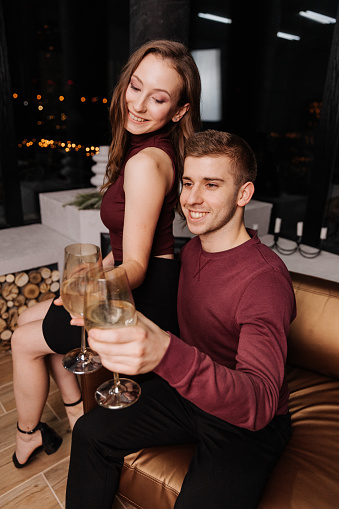 Young couple in love celebrating christmas together with a glass in their hands
