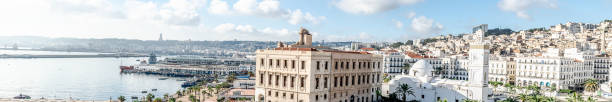 Algiers City Port and sea bay with boats and ships, Martyr's Memorial Monument, the chamber of commerce, Djamaa el Kebir the Great Mosque of Algiers and El Aurassi Hotel.