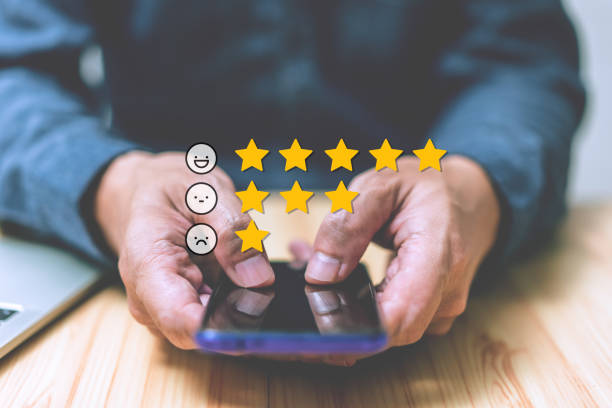 istock Hand-holding smartphone with an email icon and star emoticon over group people concept for satisfaction responding. Ratings, reviews, survey responses, information. Man using phone with laptop 1442502864