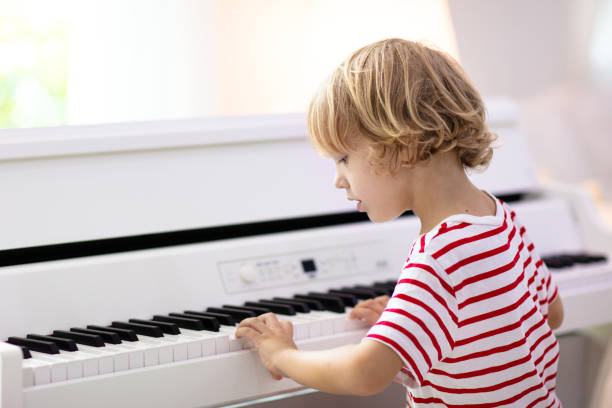 istock Child playing piano. Kids play music. 1442510312