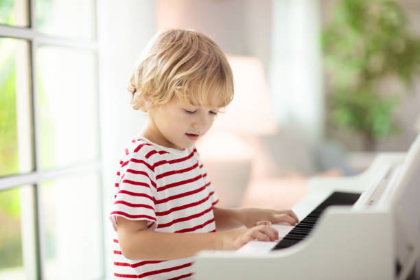 istock Child playing piano. Kids play music. 1442510334