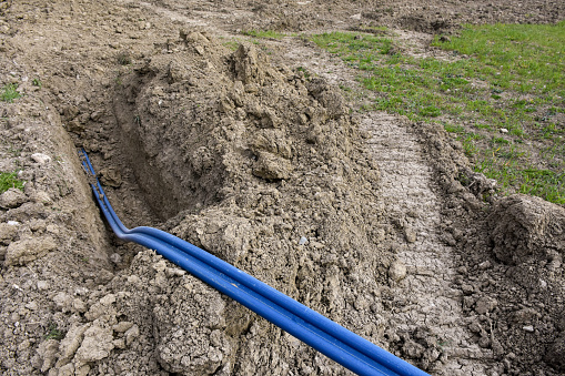 High voltage electrical cables is laid in a trench. Plastic cables in the soil