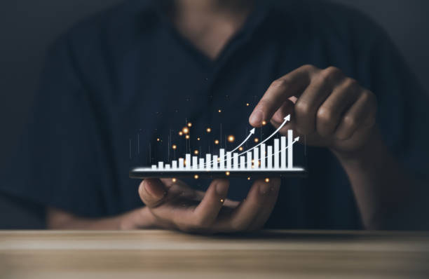 istock Hand holding a smartphone showing a stock graph Smartphone Trading 1442512524