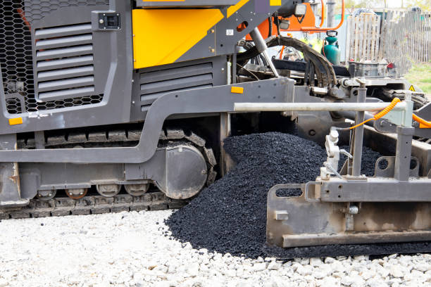 istock Worker operating asphalt paver machine during road construction and repairing works. A paver finisher, asphalt finisher or paving machine placing a layer of asphalt. Repaving 1442513966