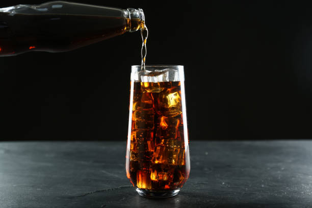 istock Pouring refreshing soda water from bottle into glass on black table 1442514754