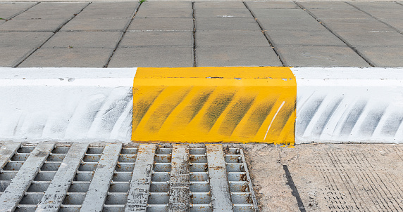Yellow and white color curb stained with tires.