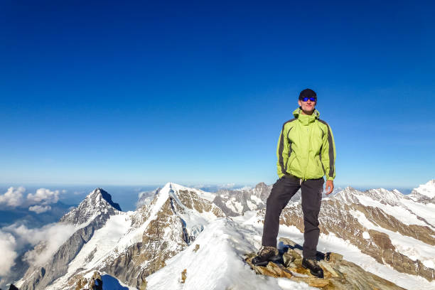 istock Enthusiastic mountaineer enjoys Jungfrau summit with  panoramic mountain view the background. Jungfrau-Höhenweg, Bernese Alps, Switzerland, Europe. 1442515689