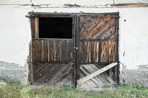 Ancient door lock in rusted iron and weathered vintage wooden door