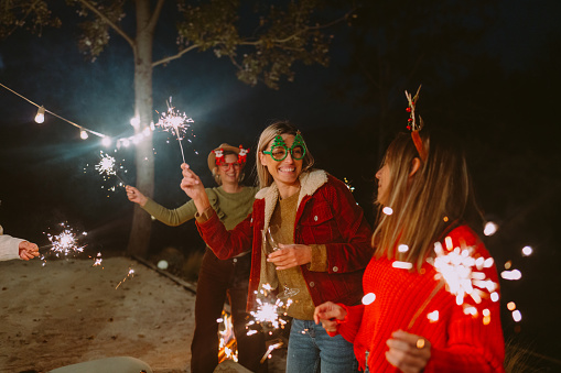 Photo of smiling girlfriends having an outdoor Christmas party