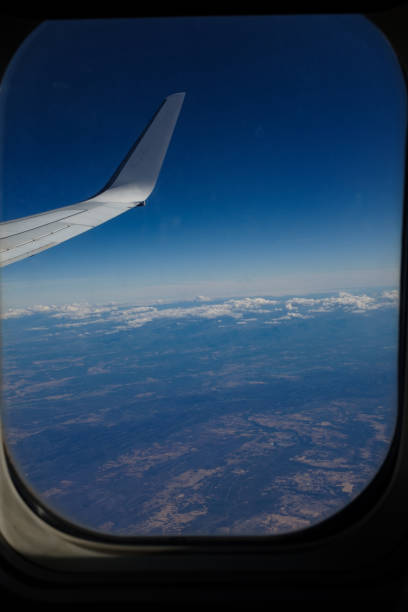 istock Airplane window frame silhouette on a beautiful sky landscape 1442519785