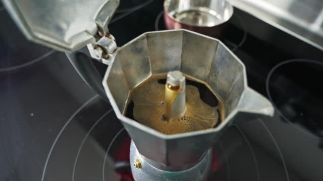Slow motion of coffee in a geyser aluminum maker maker.