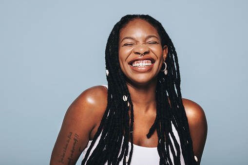 Black woman with body piercings smiling in a studio. Happy young woman feeling confident in herself.