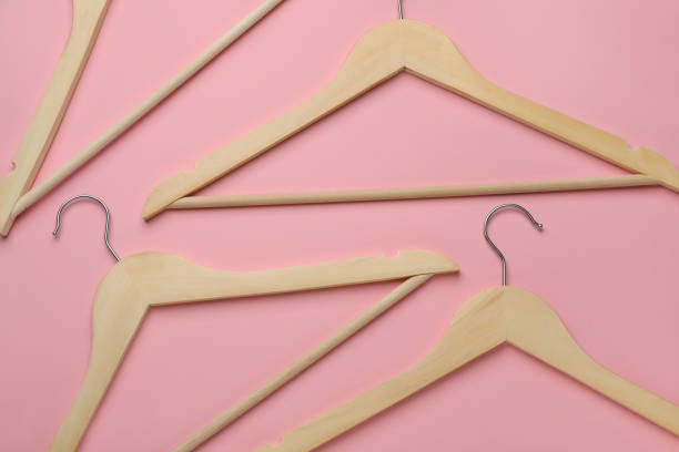 istock Empty wooden hangers on pink background, flat lay 1442524831