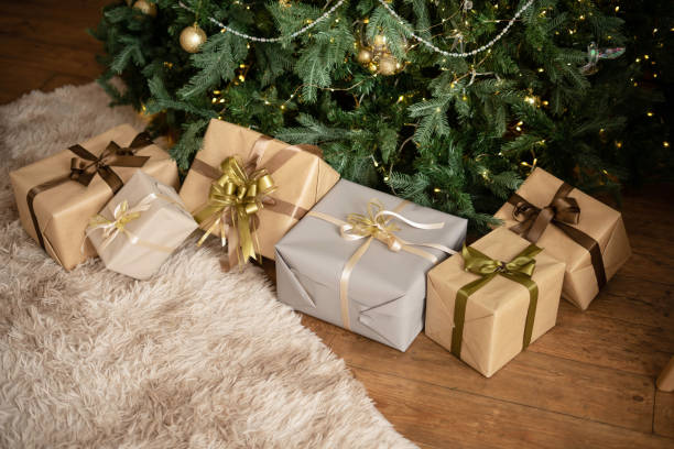 istock Christmas living room interior in studio apartment. Large decorated Christmas tree, sofa, plaid, gift boxes, fluffy carpet, light garlands. 1442529108