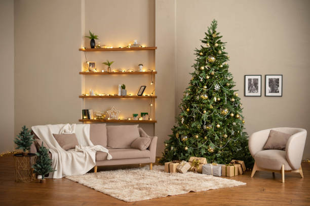 istock Modern Christmas living room interior in studio apartment. Large decorated Christmas tree, sofa, plaid, gift boxes, fluffy carpet, light garlands. 1442529677