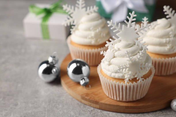 istock Tasty Christmas cupcakes with snowflakes on grey table. Space for text 1442531606