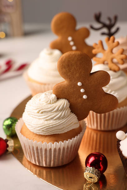 istock Tasty Christmas cupcake with gingerbread man and baubles on white table 1442534342