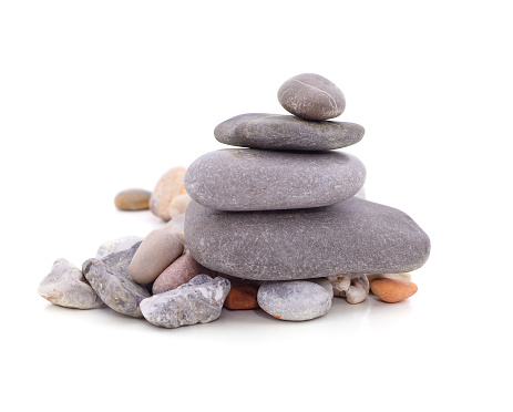 Macro photo of gray pebble stone on top of smaller stones. There are black abstract lines on big stone. Shot in studio with a full frame mirrorless camera.