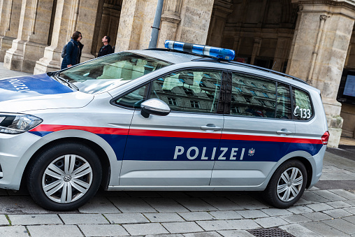 Vienna, Austria - October 14, 2022: Volkswagen police car parked on street with people around in Vienna, Austria