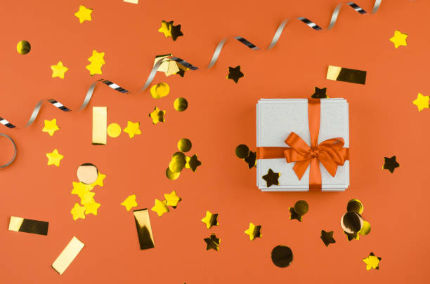 istock White gift box on an orange festive background. White gift box with orange bow 1442550983
