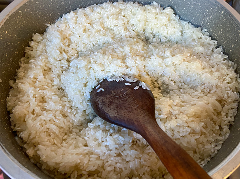 Rice in the cooking pan on the stove top burner, pilaf