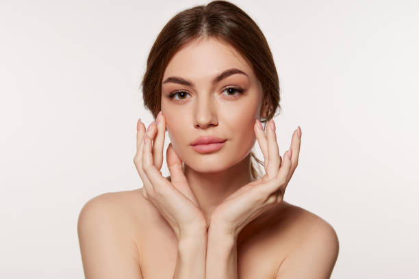 retrato de una mujer joven y hermosa con una piel lisa perfecta aislada sobre fondo blanco. cara perfecta, cuidando después de la condición de la piel - woman face fotografías e imágenes de stock