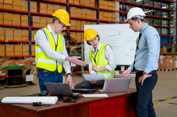 istock Group of Caucasian warehouse worker discuss about the project using paper and laptop to support the explaination of their work. 1442558595