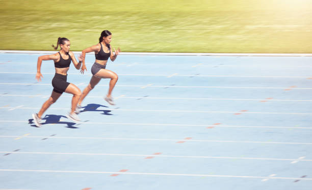 스포츠, 스프린트 러너 여성은 힘, 속도 및 동기 부여를 위해 렌즈 플레어로 경기장에서 경쟁합니다. 프로 운동 선수 피트니스 사람들 마라톤 달리기, 목표 훈련, 도전 및 에너지 - exercising sports training lens flare women 뉴스 사진 이미지