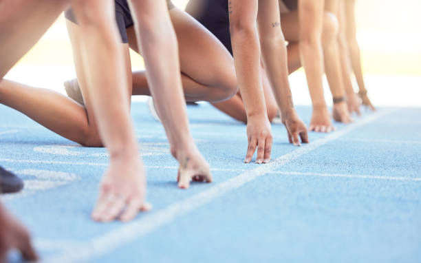 istock Runners with hands on start line on the track for a race, ready to run. Racing challenge or sprint at sports event with closeup for motivation, concentrate and focus in athletes running on track 1442560302